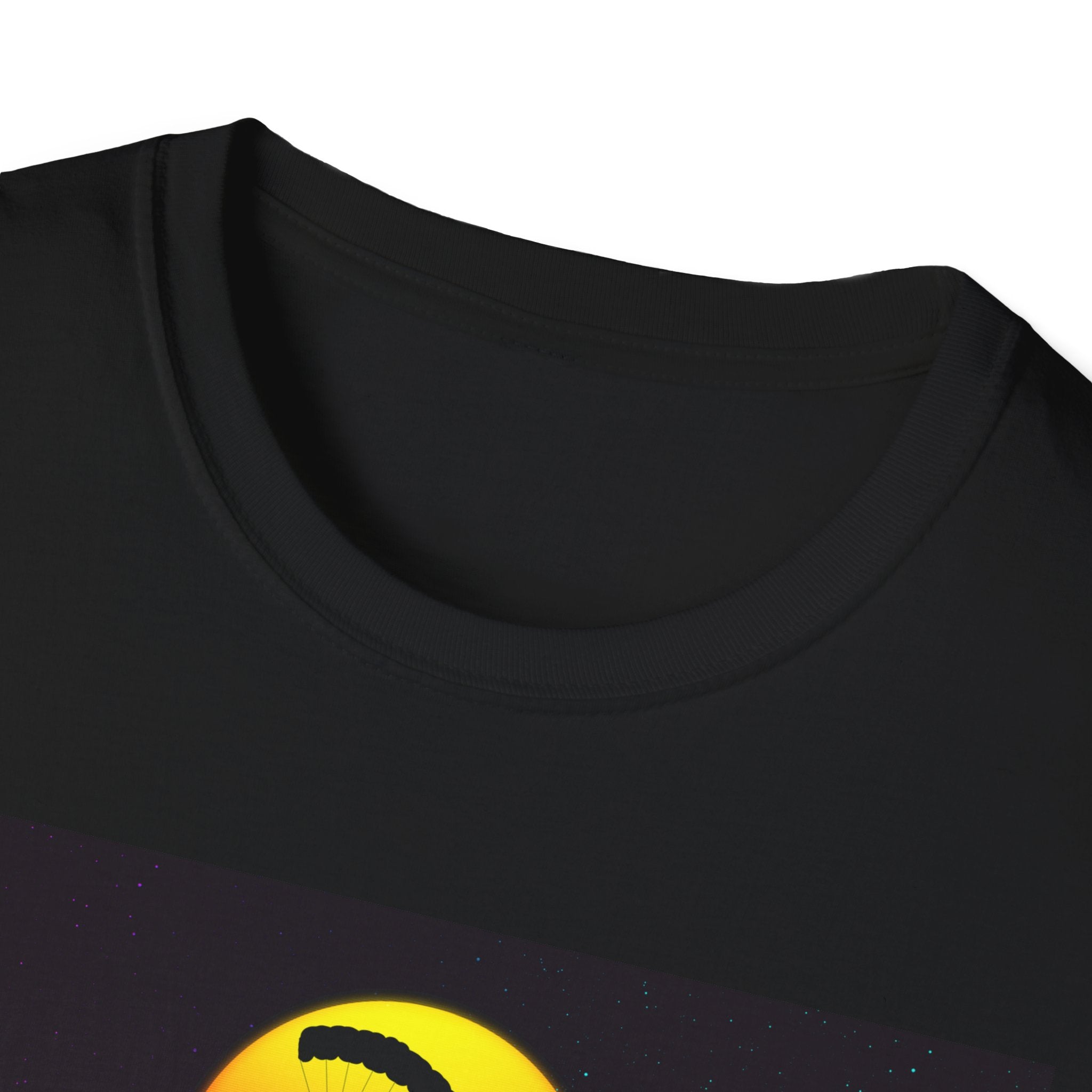 Close-up of a black t-shirt with a yellow circle design featuring a black object on a white background